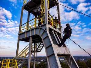 Zdjęcie policjanta w trakcie wspinaczki na szyb kopalniany