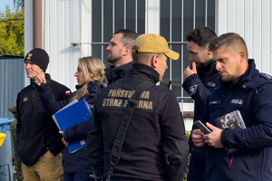 Zdjęcie ukazujące rozmawiających strażaków i policjantów