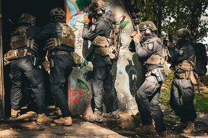 Uzbrojeni mundurowi w trakcie wejścia do budynku