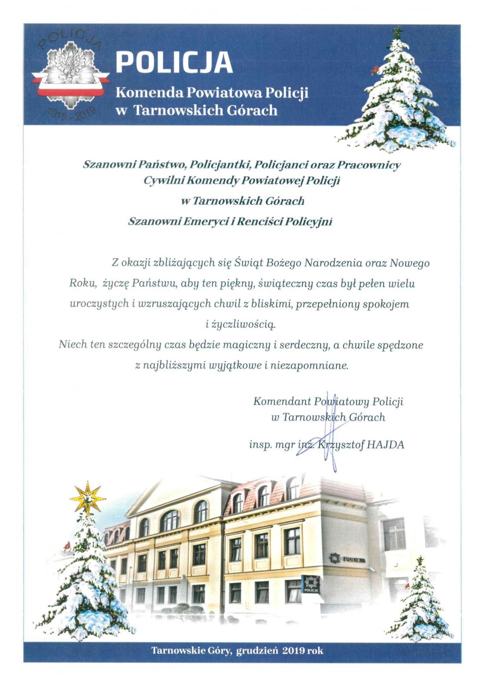 Grafika - budynek Komendy Powiatowej Policji w Tarnowskich Górach, obok którego znajdują się ośnieżone choinki. Tekst na grafice - Życzenia Komendanta Powiatowego Policji w Tarnowskich Górach 
