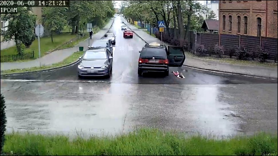 Na zdjęciu widać skrzyżowanie, na którym z jednego z widocznych samochodów, przez tylne drzwi wypada dziecko