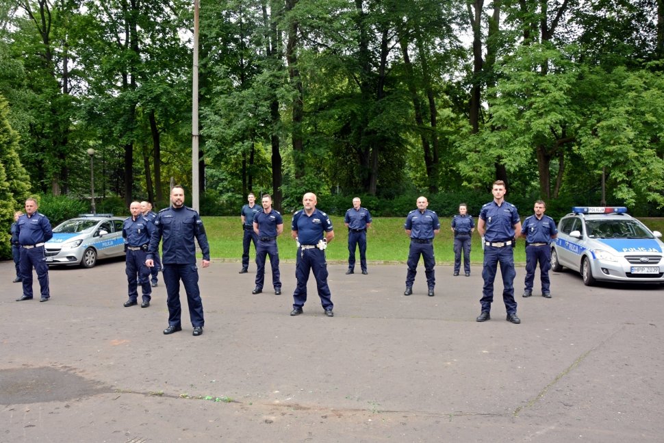 na zdjęciu widać park, na terenie którego znajduje się grupa policjantów 