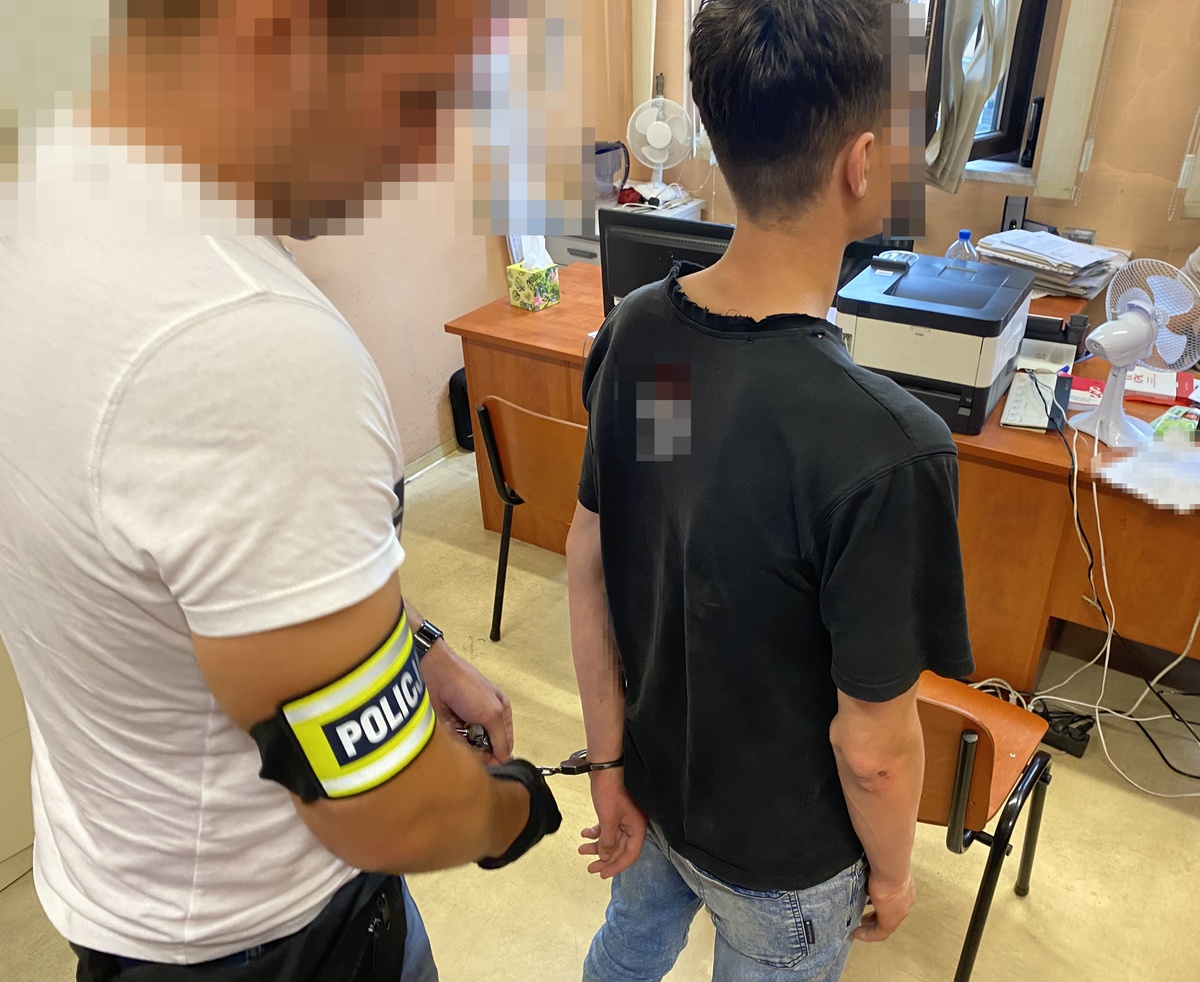 policjant w ubiorze cywilnym i sprawca zniszczenia mienia stojący przed nim