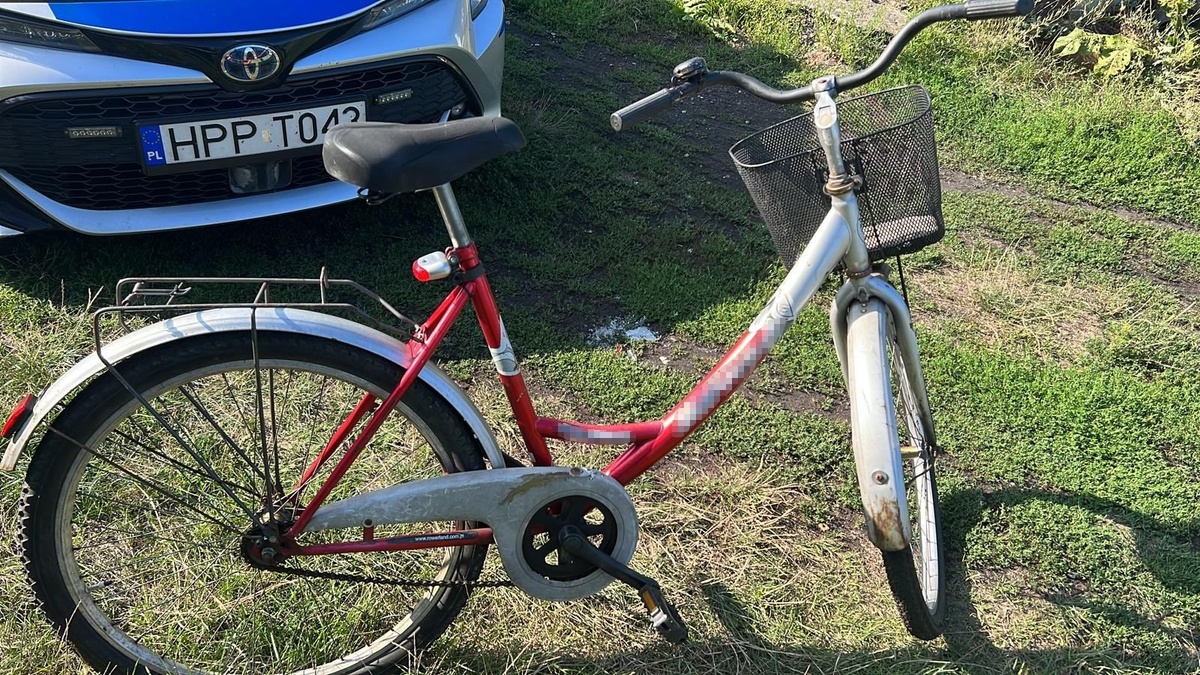 odzyskany przez policjantów rower, w tle przód policyjnego radiowozu