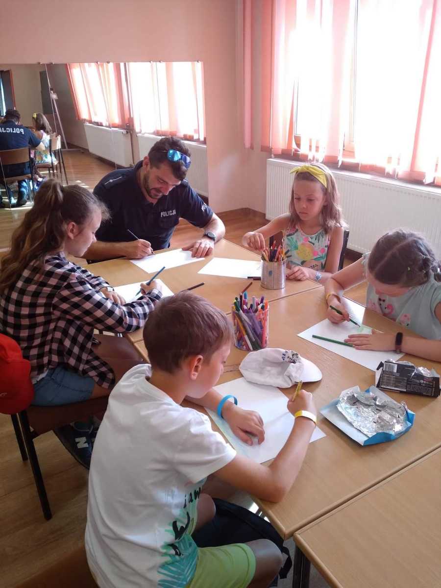 policjant przy stole z dziećmi