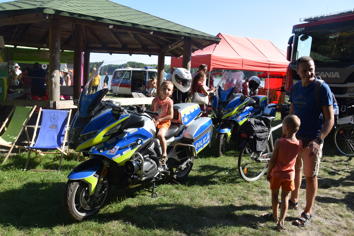 Na zdjęciu widoczni uczestnicy pikniku, radiowóz i motocykle