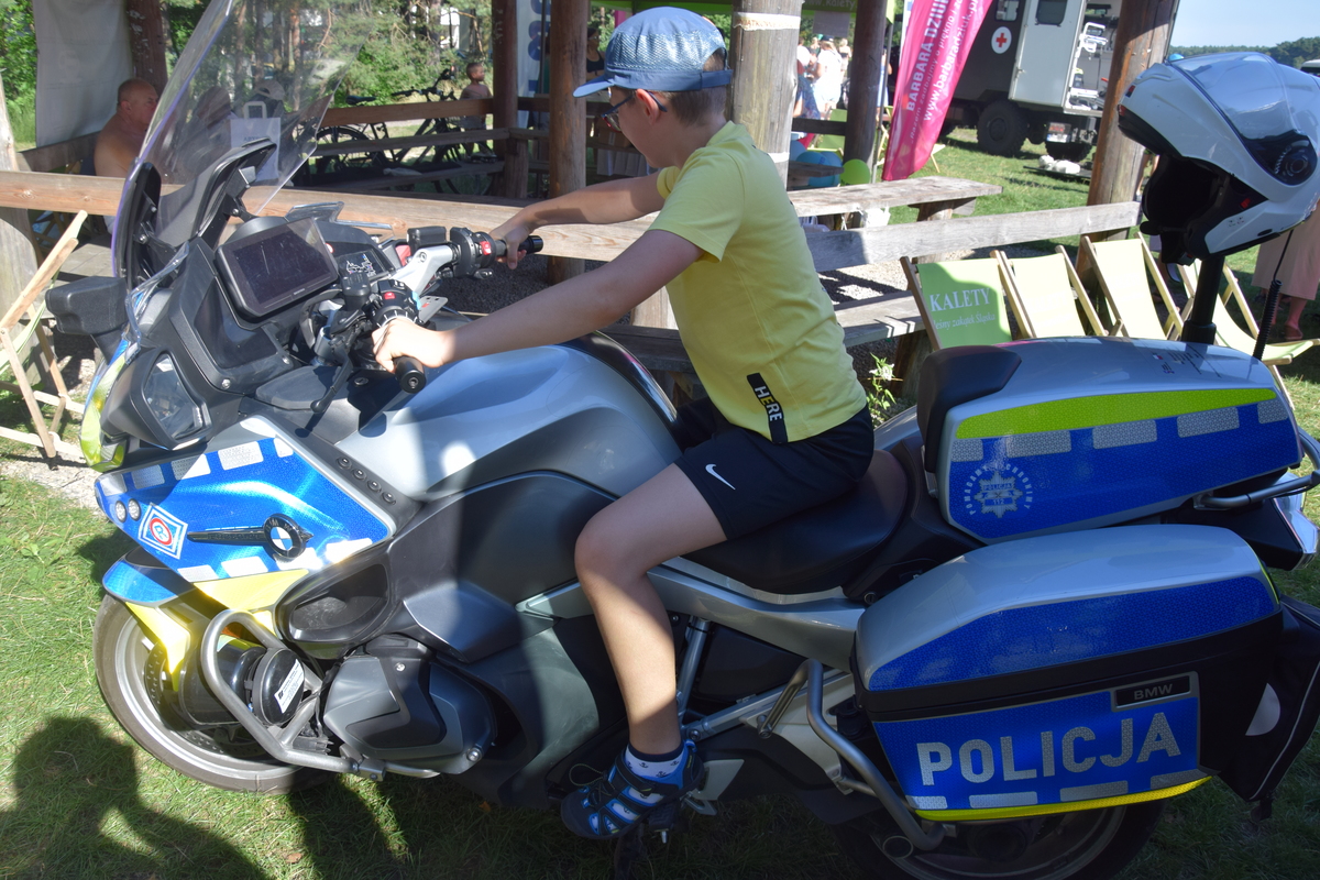 Na zdjęciu widoczni uczestnicy pikniku, radiowóz i motocykle