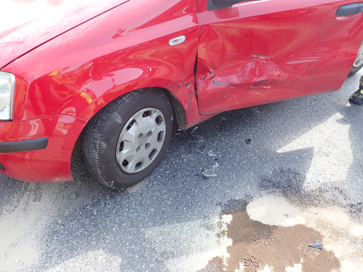 na zdjęciu bok uszkodzonego czerwonego pojazdu