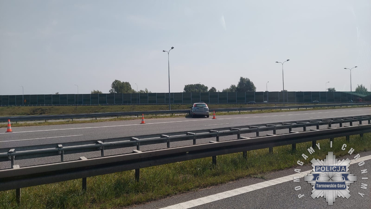 na zdjęciu pojazd przodem do bariery energochłonnej na autostradzie odgrodzony pomarańczowymi pachołkami 
