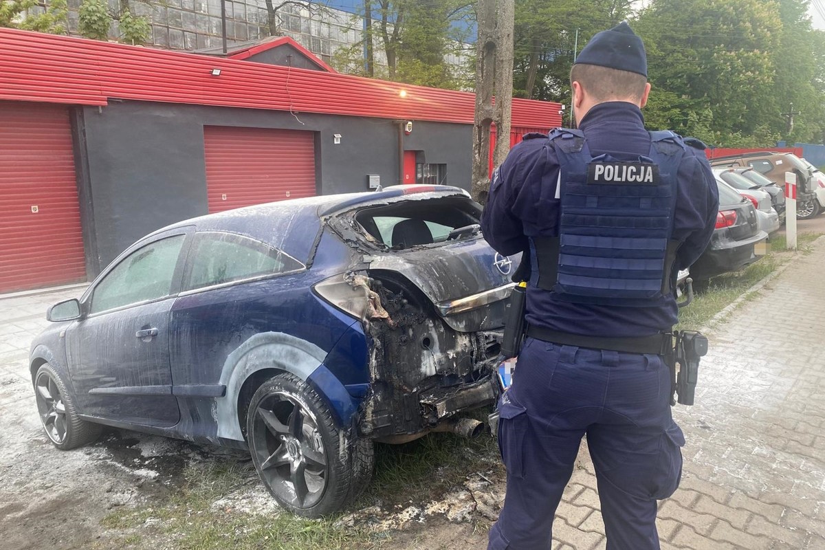 na zdjęciu policjant przy nadpalonym samochodzie