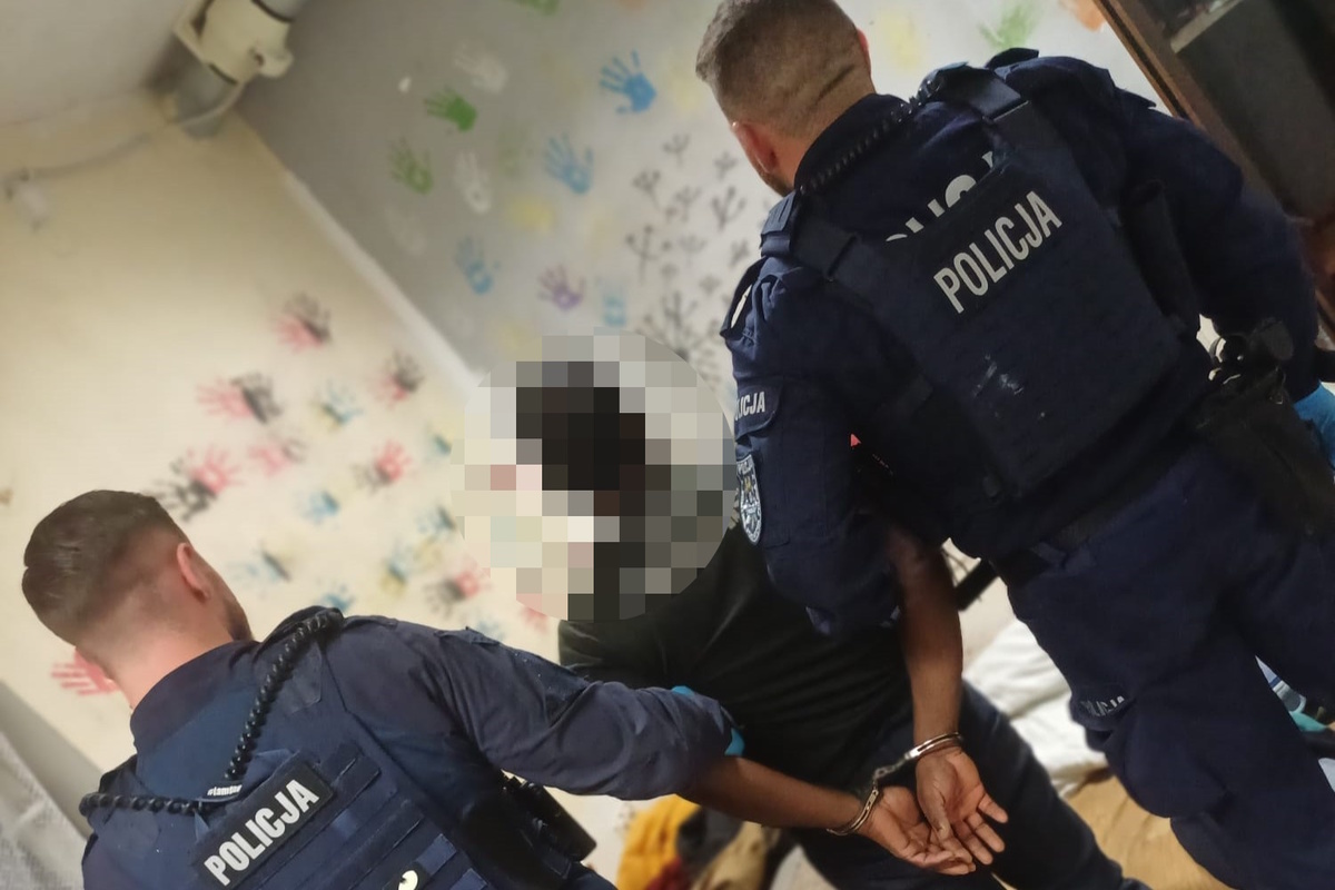 na zdjęciu policjant obok zatrzymanego mężczyzny 