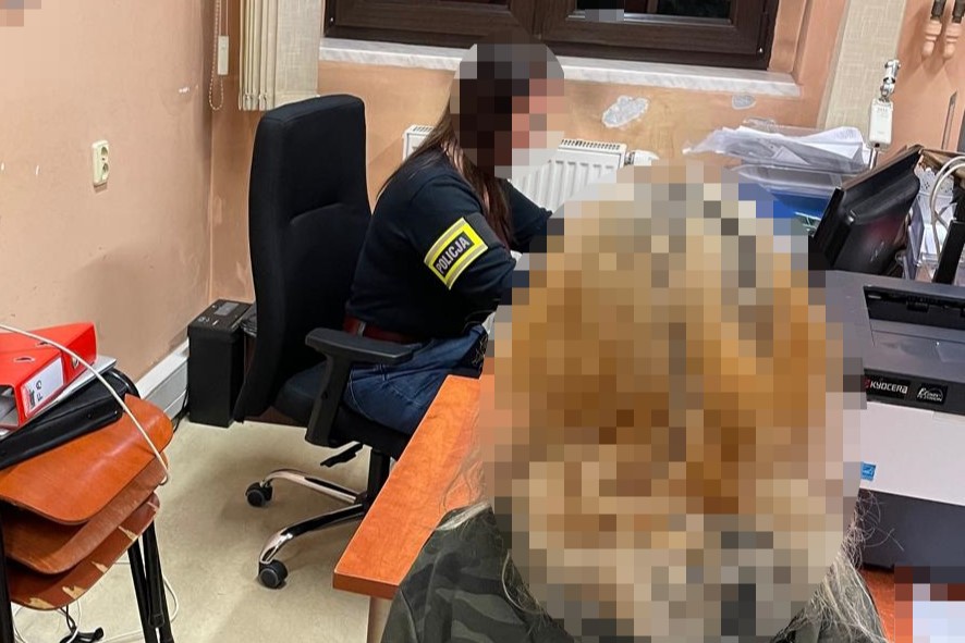 na zdjęciu nieletnia przy biurku, za którym siedzi policjantka z opaską na ramieniu 