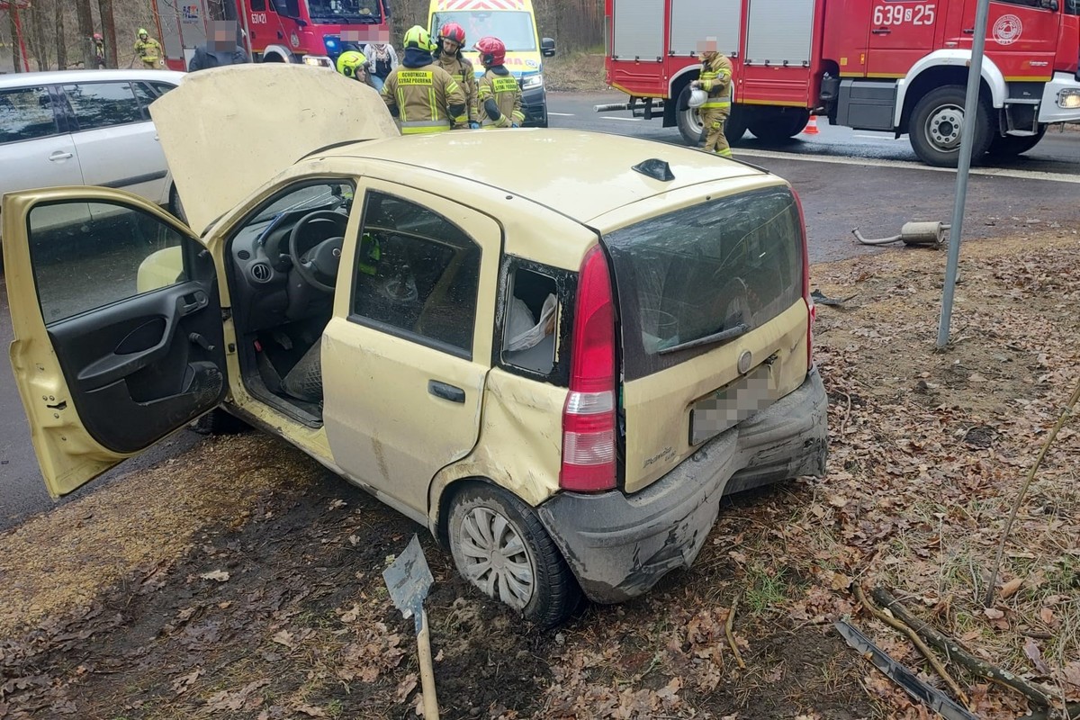 na zdjęciu pojazd z uszkodzeniami, przed nim strażacy, osoby i wozy służb
