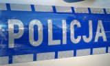 napis policja na niebieskim tle na karoserii radiowozu