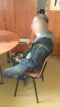 mężczyzna, sprawca włamania siedzący na krześle w biurze