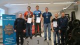 zdjęcie przedstawia salę siłowni, w której na podium stoją sportowcy - policjanci