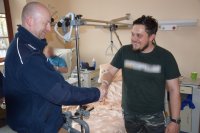 Zdjęcie przedstawia sierż. szt. Michała Tomanka oraz asp. szt. Daniela Napiórkowskiego, który gratuluje policjantowi bohaterskiej postawy