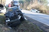 Zdjęcie przedstawia  znajdujący się w rowie samochód osobowy marki BMW. Samochód ma rozbity przód i uniesioną maskę