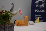 Zdjęcie przedstawia stroik świąteczny. W tle widać policyjny baner