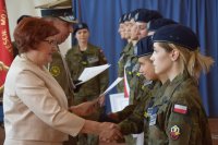 Zdjęcie przedstawia dyrektora szkoły oraz przedstawiciela wojska wręczających uczniom certyfikaty