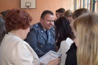 Zdjęcie przedstawi Komendanta Policji oraz dyrektora szkoły wręczających uczniom certyfikaty
