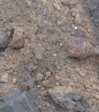 Zdjęcie przedstawia leżący w ziemi niewybuch -  Panzerschreck
