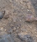 Zdjęcie przedstawia leżący w ziemi niewybuch -  Panzerschreck