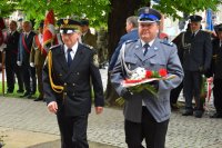 Zdjęcie przedstawia  niosącego kwiaty Pierwszego Zastępcę Komendanta Powiatowego Policji w Tarnowskich Górach podinsp. Sławomira Bylickiego. Z jego lewej strony znajduje się  Komendanta Straży Miejskiej.