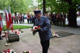 Zdjęcie przedstawia składającego kwiaty Pierwszego Zastępcę Komendanta Powiatowego Policji w Tarnowskich Górach podinsp. Sławomira Bylickiego. w tle widać Komendanta Straży Miejskiej oraz poczty sztandarowe.