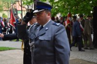 Zdjęcie przedstawia  oddającego honor Pierwszego Zastępcę Komendanta Powiatowego Policji w Tarnowskich Górach podinsp. Sławomira Bylickiego. w tle widać  Komendanta Straży Miejskiej oraz poczty sztandarowe.