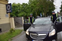 Zdjęcie przedstawia dwóch policjantów z Wydziału Ruchu Drogowego wsiadających do nieoznakowanego radiowozu.
