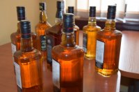 zdjęcie przedstawia kilka butelek alkoholu, który został odzyskany  przez tarnogórskich policjantów