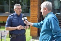 Na zdjęciu patrząc od lewej strony widać asp. szt. Adama Cichowskiego oraz redaktora Telewizji Śląskiej. Policjant udziela wywiadu.