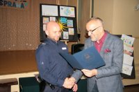 Na zdjęciu widać dzielnicowego sierż. szt. Grzegorza Szeligę oraz mężczyznę, który wręcza mu list gratulacyjny.