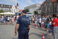 policjant obrócony tyłem a w tle osoby podczas pikniku mundurowego