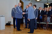 Na fotografii widać Komendanta Wojewódzkiego Policji w Katowicach nadinsp. Krzysztofa Justyńskiego, który wita się z Naczelnikiem Wydziału Prewencji kom. Piotrem Skolikiem.  W tle fotografii widać Posła na Sejm RP Tomasza Głogowskiego, Komendanta Powiatowego Policji w Tarnowskich Górach mł. insp. Krzysztofa Hajdę oraz zaproszonych gości.