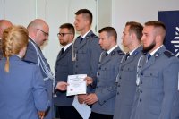 Na fotografii widać Komendanta Wojewódzkiego Policji w Katowicach nadinsp. Krzysztofa Justyńskiego, który wręcza policjantom akty mianowania.