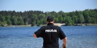 na fotografii widać policjanta obserwującego zbiornik wodny