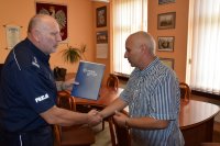 Na fotografii widać inspektora Krzysztofa Hajdę oraz Pana Mirosława. Komendant wręcza mu pisemne podziękowania.