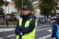 Na fotografii widać policjanta, który obserwuje ulicę.