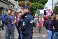 Na fotografii widać ludzi. Pośród nich widać policjanta.