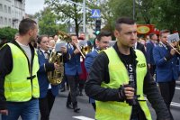 Na fotografii widać dwóch policjantów, którzy idą obok uczestników pochodu.