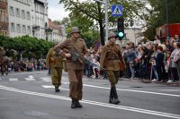 Na fotografii widać idących ulicą uczestników pochodu. Przebrani są za historyczne postacie. Po obydwu stronach ulicy znajduje się tłum ludzi.