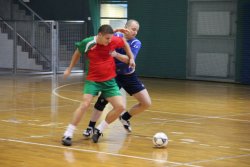 zdjęcie przedstawia halę sportową, na której graja dwaj piłkarze