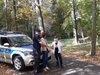 Na fotografii widać policyjny radiowóz, przed którym stoi policjant, kobieta i Miłosz. Chłopiec na głowie ma policyjną czapkę, a w ręku trzyma kajdanki.