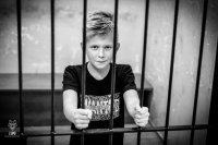 Na fotografii widać Miłosza, który stoi za kratami.