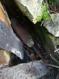 Na fotografii widać leżący w gruzie pocisk artyleryjski