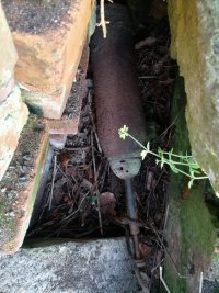 Na fotografii widać leżący w gruzie pocisk artyleryjski