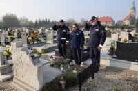 Na fotografii widać cmentarz, na którym znajduje się Komendant Powiatowy Policji w Tarnowskich Górach insp. Krzysztof Hajda, Zastępca Naczelnika Prewencji Zbisław Pawłowski oraz kapelan policji diecezji gliwickiej ks. Joachim Gondro. Policjanci oddają honor.