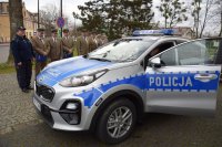 Na fotografii widać policyjny radiowóz, dookoła którego stoją: Pierwszy Zastępca Komendanta Powiatowego Policji w Tarnowskich Górach podinsp. Sławomir Bylicki, Komendant Komisariatu Policji w Tworogu, Wójtowie Gmin w Tworogu i Krupskim Młynie oraz przedstawiciele Nadleśnictw.